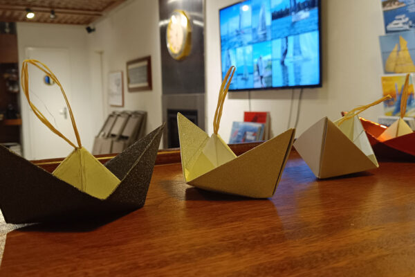 Enfants fabriquant des bateaux en origami au Club Nautique de Crans